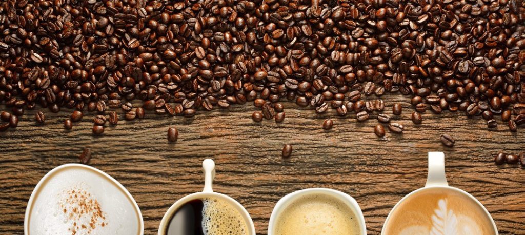 Кофейные зерна и чашки с разными видами кофе
